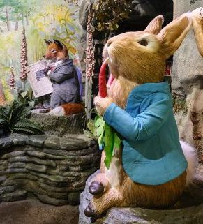 Scene with Peter Rabbit and other Beatrix Potter characters in a whimsical indoor display, featuring detailed figures, props, and colorful painted backdrops.