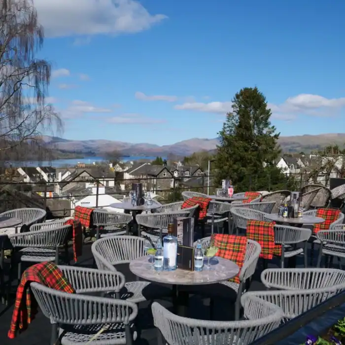 Charming rooftop terrace at The Ro Hotel with lake and mountain views, outdoor dining and cozy ambiance.