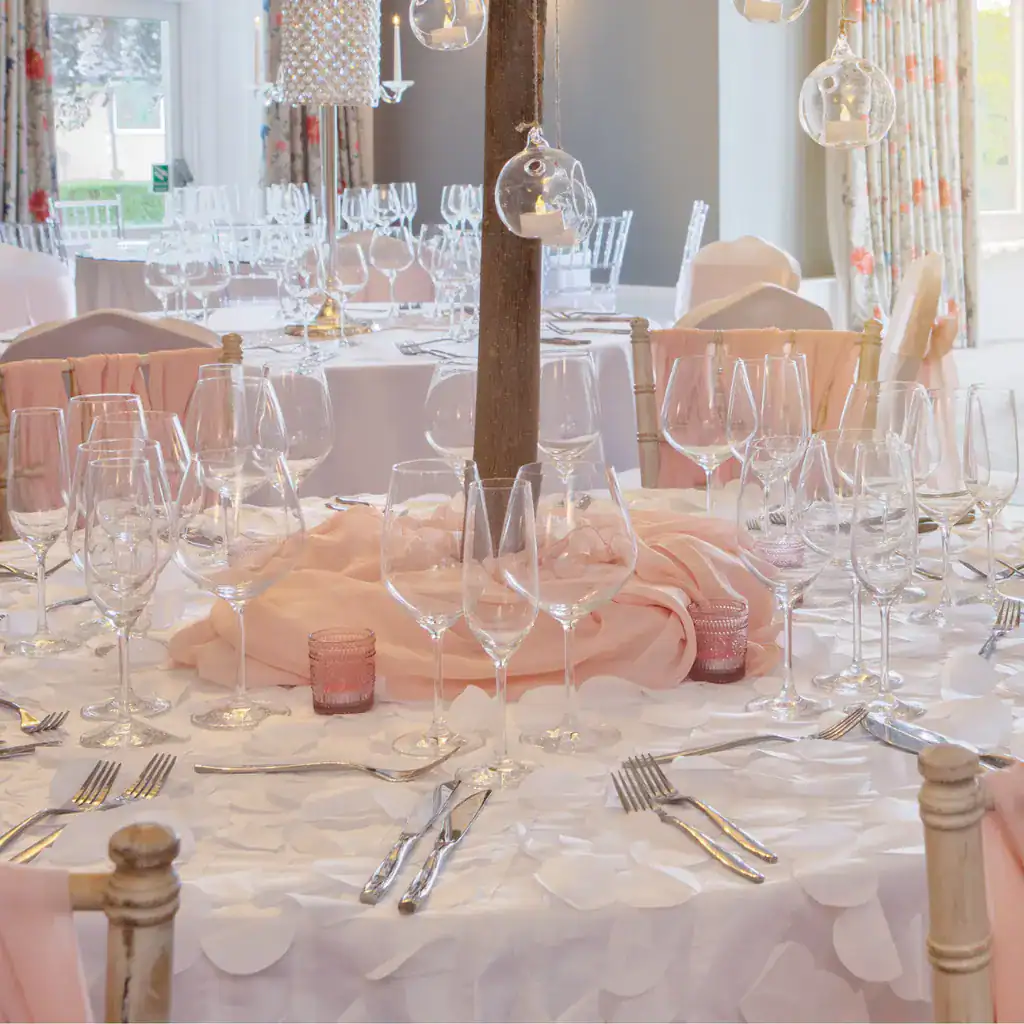 Luxurious wedding reception setup with elegant tableware, glassware, and floral decorations at The Ro Hotel.