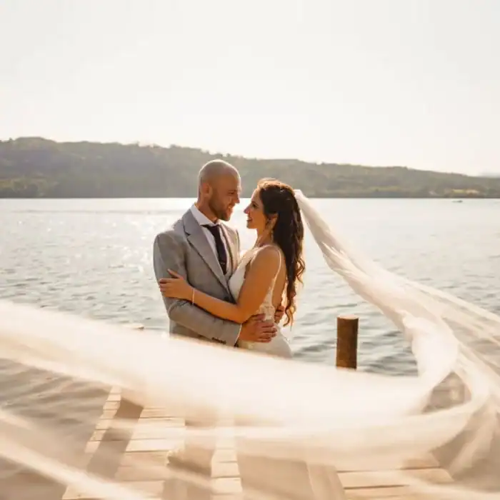 Romantic couple on a dock by the water at The Ro Hotel, perfect for weddings and events.