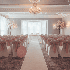 Elegant wedding ceremony setup with floral decor and chandeliers at The Ro Hotel.