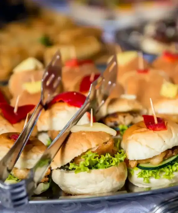 Mini slider sandwiches with lettuce, cheese, and toppings at The Ro Hotel restaurant.