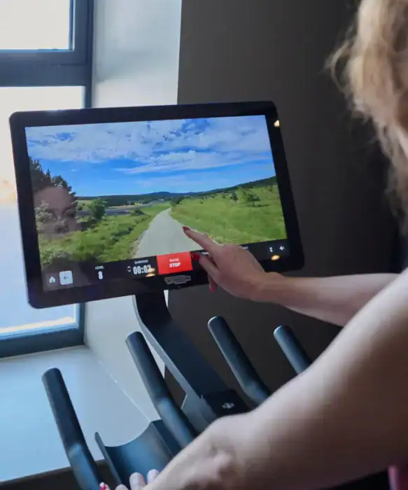 Serene landscape on a treadmill screen at The Ro Hotel, offering a scenic workout experience.