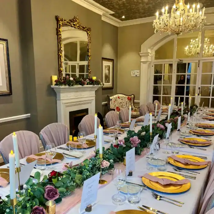Elegant hotel dining room with floral centerpiece, chandeliers, and sophisticated decor at The Ro Hotel.