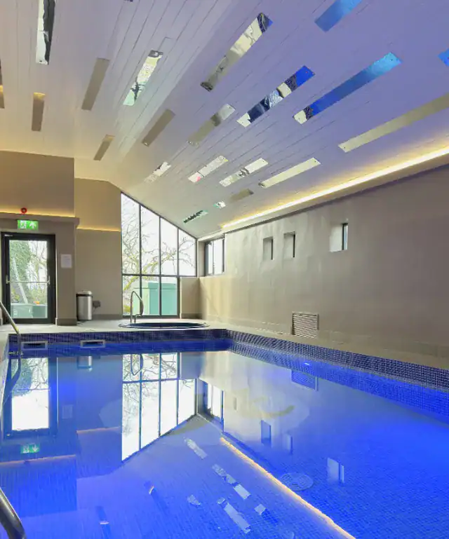 Relaxing indoor pool at The Ro Hotel with modern design and natural light.