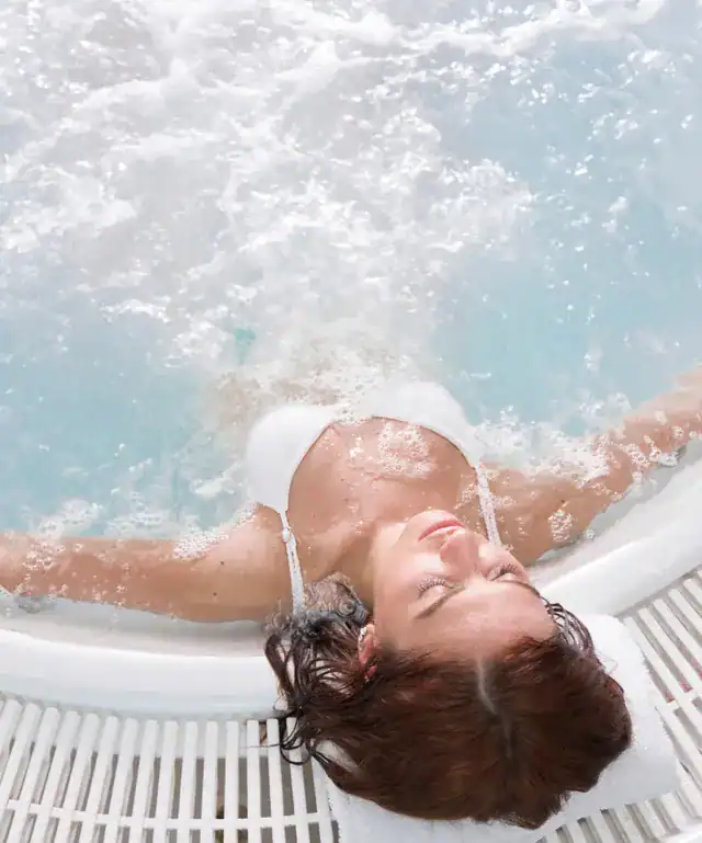 Relaxing woman enjoying hot tub at The Ro Hotel, perfect for relaxation and wellness.