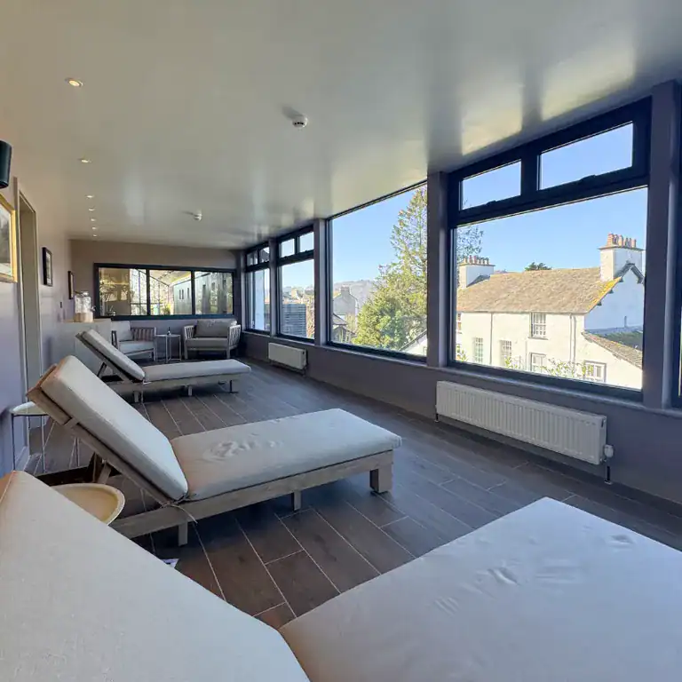 Spacious lounge area with large windows offering city views at The Ro Hotel.