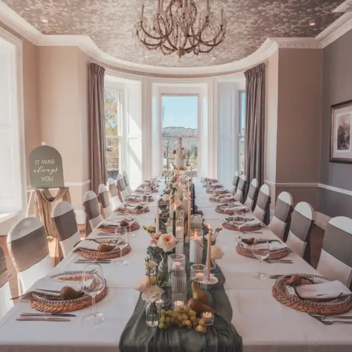 Elegant dining room at The Ro Hotel with a beautifully set table and scenic window views.