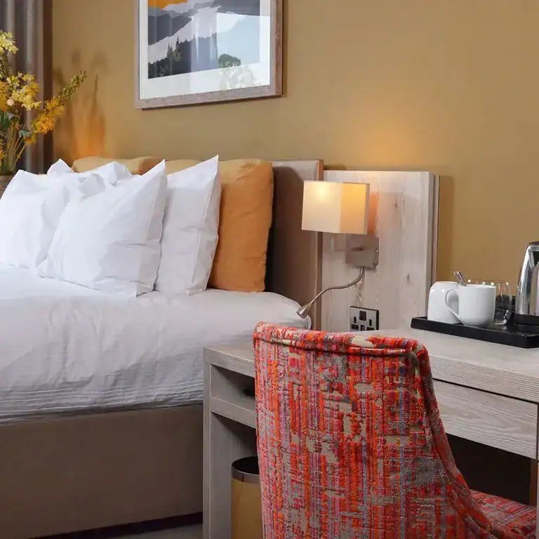 Cozy hotel room with modern decor, comfortable bed, and inviting lighting at The Ro Hotel.