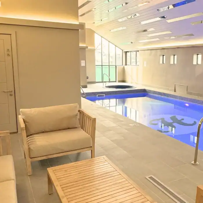 Luxurious indoor pool at The Ro Hotel with spa hot tub and modern design, perfect for relaxation.