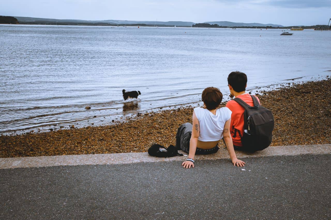 Romantic Break in Lake District The Ro Bowness on Windermere Hotel Young couple sat on the edge of a lake with their dog in the water